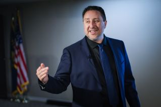 Speaker engages an audience during a business seminar in a modern conference room.